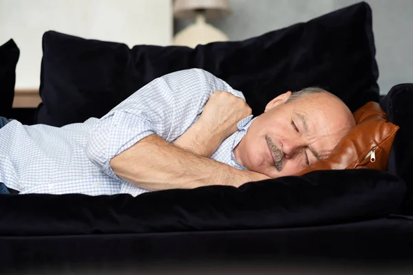 Cansado hispânico sênior homem dormindo no sofá, tendo cochilo da tarde — Fotografia de Stock