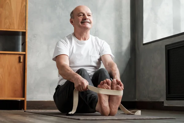 Ältester hispanischer Mann sitzt in Paschimottanasana oder intensiver Rückenstreckpose — Stockfoto