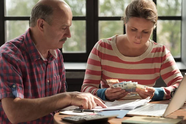 Filha ajuda seu pai a contar dinheiro e gerenciar o orçamento familiar . — Fotografia de Stock