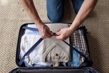 Yaşlı adam elleri bavul içinde giysi ambalaj.