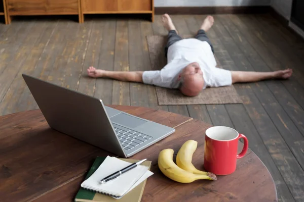 Petunjuk kabur dari pria senior kaukasia yang terbaring di Shavasana berpose — Stok Foto