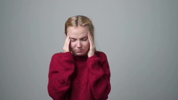 Mujer joven que sufre un dolor de cabeza presionando las sienes con los dedos . — Vídeos de Stock