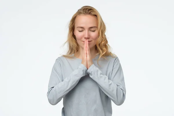 Mujer cogida de la mano en namaste u oración, manteniendo los ojos cerrados mientras medita . —  Fotos de Stock