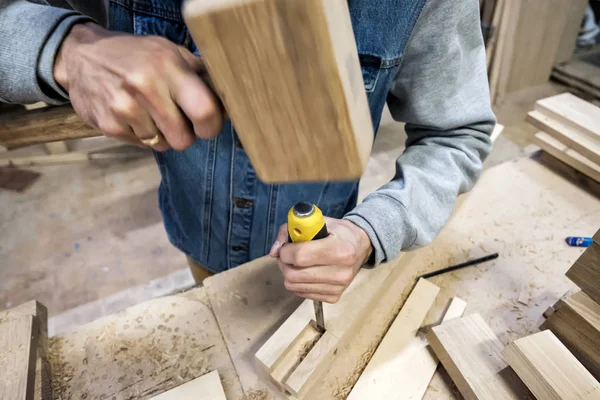 Falegname fa un buco nel dettaglio mobili in legno con un martello e scalpello . — Foto Stock