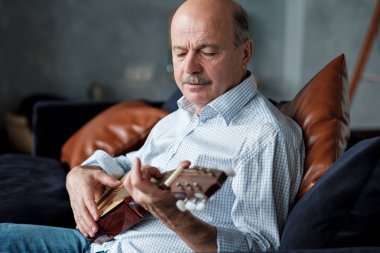 Evde kıdemli İspanyol adam gitar çalmayı öğrenme.