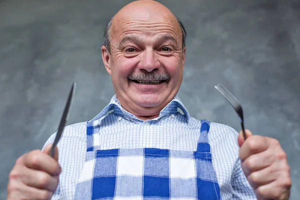 Senior hispanic hungry man holding a fork and a knife. — Stock Photo, Image