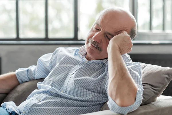 man sleeping on couch, taking afternoon nap at the living room