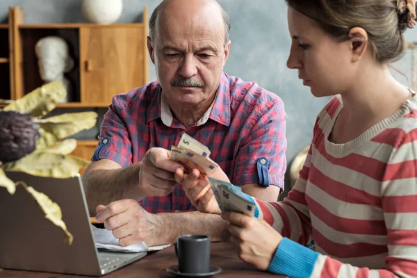 Homem espanhol idoso dá dinheiro a sua filha para uma hipoteca ou empréstimo estudantil . — Fotografia de Stock