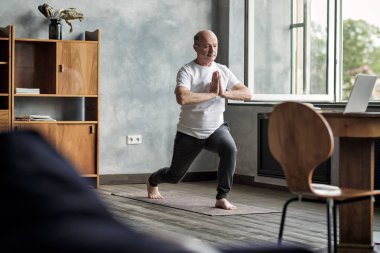 Savaşçı yoga poz varyasyon ayakta Kıdemli İspanyol adam