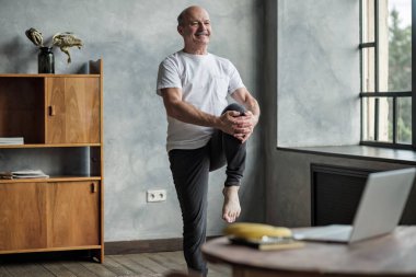 Bir bacak yoga dengesi ayakta Kıdemli İspanyol adam.