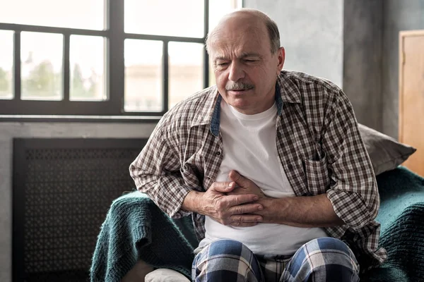 Senior hispanic man is having pancreatitis or gastritis or colitis. — Stock Photo, Image