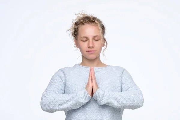 Mujer cogida de la mano en namaste u oración, manteniendo los ojos cerrados mientras medita —  Fotos de Stock