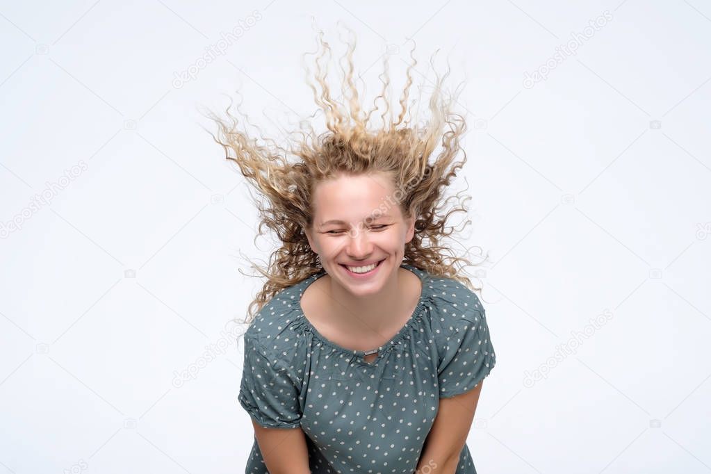 Blonde young model in studio with hair blown by wind