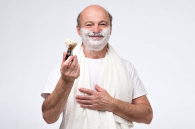 Olgun İspanyol adam sakal ve bıyık üzerinde tıraş köpüğü koymak.