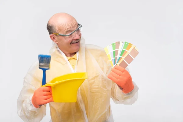 Hispano maduro pintor hombre con muestras de color en la mano — Foto de Stock