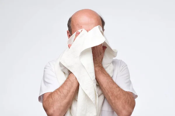 Senior hispanic man wiping his face with towel after washing it. — Stock Photo, Image