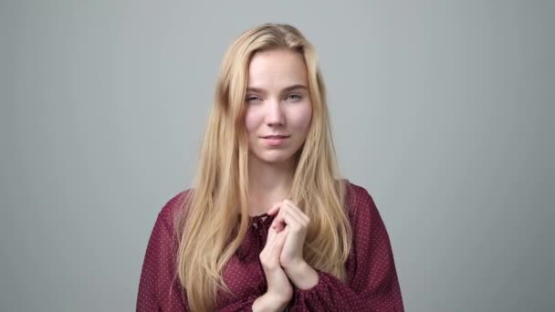 Hinterhältige, listige, blonde junge Frau, die etwas plant — Stockvideo