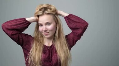 Genç sarışın kadın onu uzun saçları ile oynar.