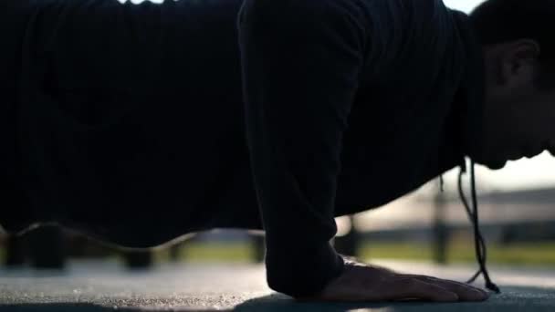 A man doing a push up in a park on cold weather. Close up view. — Stock Video