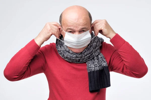 Mann verschließt Gesicht mit medizinischer Maske zum Schutz vor Smog oder Virus. — Stockfoto