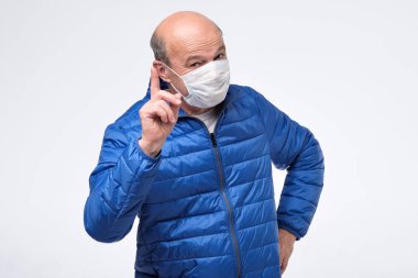 Tıbbi maskeli kıdemli adam tavsiye veriyor