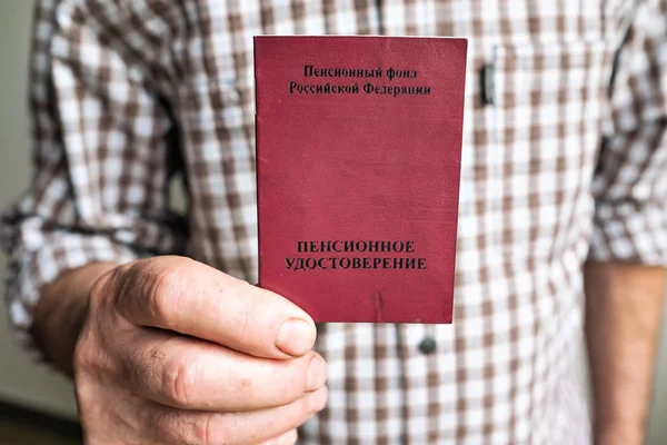 Saint-Petersburg, Ryssland-september 05, 2019: pensionerade man Holding dokument. Det är skrivet pensions-ID på omslaget. — Stockfoto