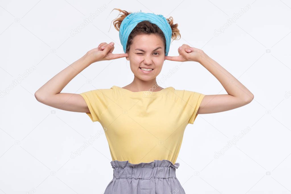 woman plugging ears, pretending not to hear what she is told.