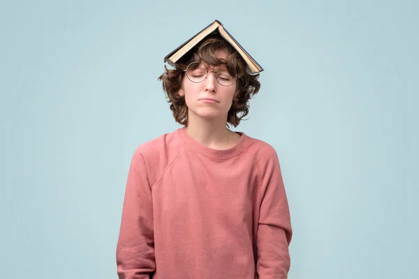 Ung student i pin kpullover med bok över huvud — Stockfoto