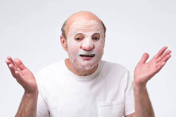 Spansktalande mogen man i en kosmetisk mask hudvård — Stockfoto