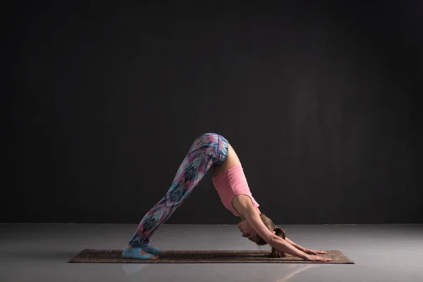 Meisje stretching in naar beneden gerichte hond yoga pose, adho mukha svanasana — Stockfoto