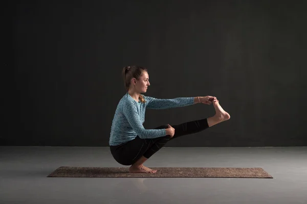 Ung vacker kvinna i yogaposer som balanserar på ett ben. — Stockfoto