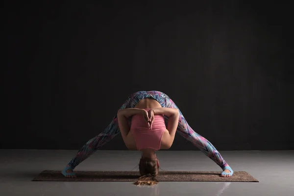 Mulher fazendo postura Prasarita Padottanasana ioga. Estúdio — Fotografia de Stock