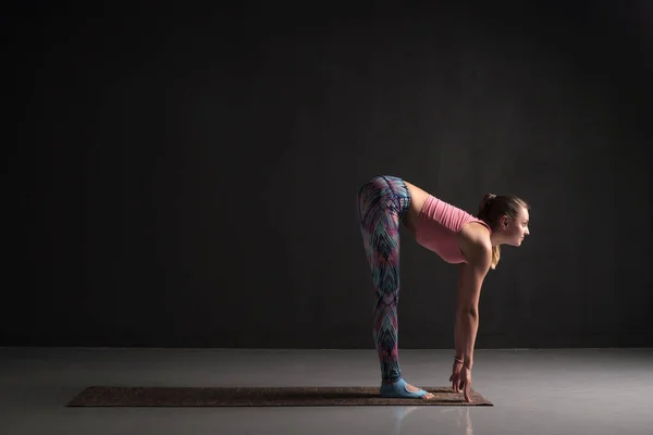 Mujer está trabajando de pie doblar hacia adelante o uttanasana asana — Foto de Stock