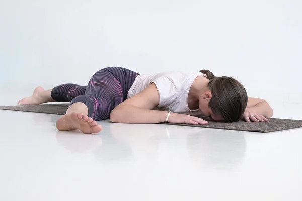 Kvinna arbetar ut gör yoga eller pilates motion stretching hennes ben — Stockfoto