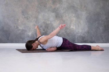 Eka Pada Rajakapotasana için stüdyoda yoga hazırlığı yapan kadın.