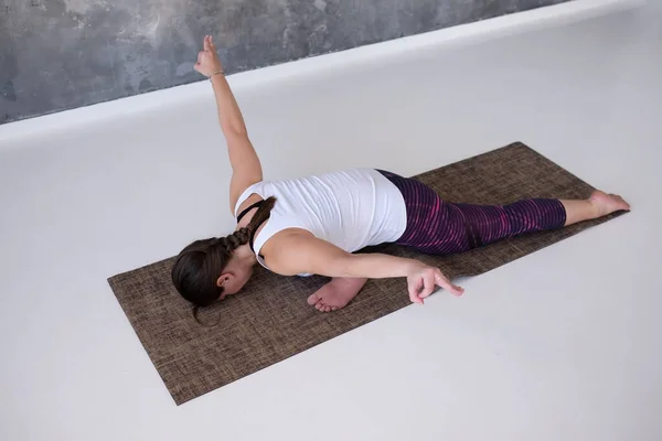 Woman practicing yoga preparing for Eka Pada Rajakapotasana in studio — Stock Photo, Image