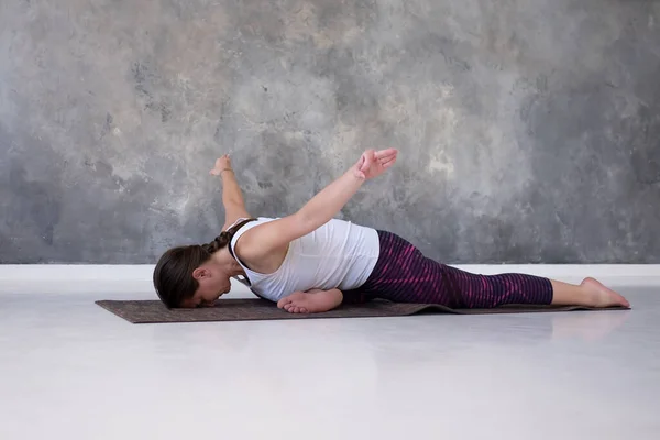 Woman practicing yoga preparing for Eka Pada Rajakapotasana in studio — Stock Photo, Image