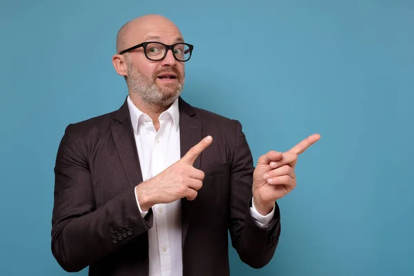 business man in suit and glasses pointing on important information aside.