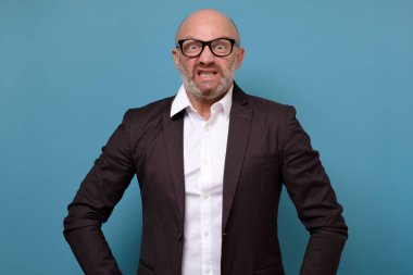 Takım elbiseli ve gözlüklü bir iş adamı sıkıntıdan patlıyor.