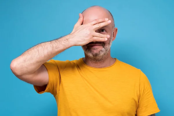 man covering his face by hand, peeping trying to find put a top secret
