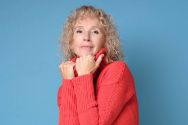 Kıdemli kadın kameraya kendinden emin bakıyor..