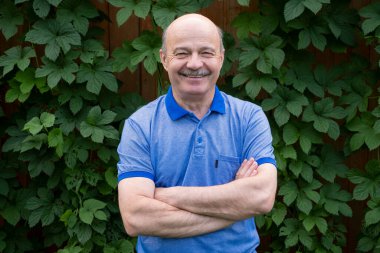 Mutlu yaşlı yaşlı adam dışarıda gülümsüyor..