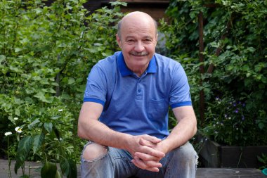 Mutlu yaşlı yaşlı adam dışarıda gülümsüyor..