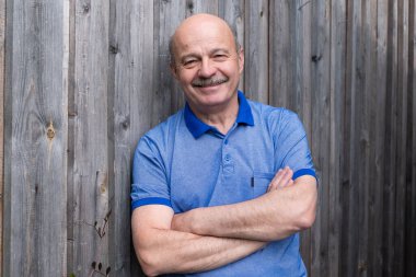 Mutlu yaşlı yaşlı adam dışarıda gülümsüyor..