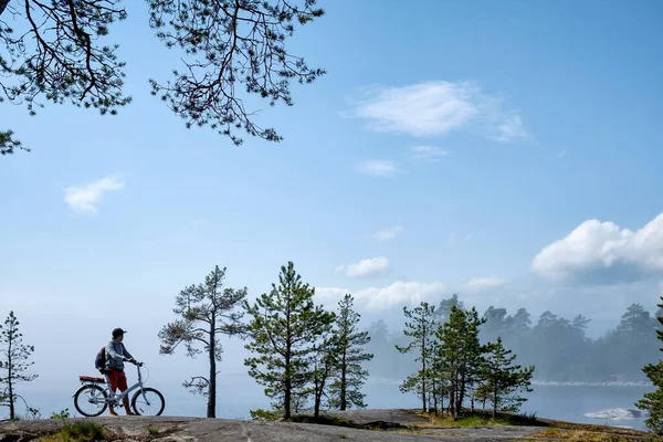 Junge Männer morgens mit dem Fahrrad auf Radweg am See. — Stockfoto