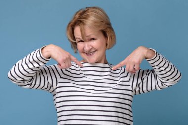 Mutlu olgun kadın kendini işaret ediyor. Lütfen beni seçin..