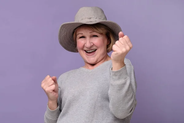 Feliz anciano caucásico mujer en verano sombrero bombeo puños hasta, celebrar el éxito — Foto de Stock