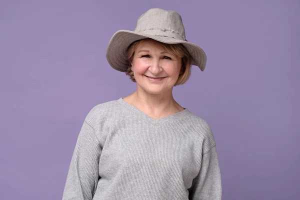 Mujer mayor sonriente en sombrero de verano riendo mirando a la cámara . —  Fotos de Stock