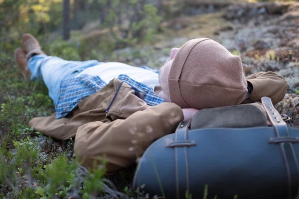 Erholsamer junger Mann legt sich auf den Boden eines Waldes oder Parks — Stockfoto