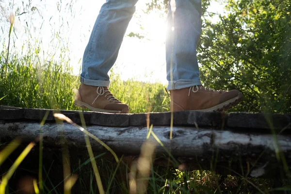 Vista de las botas de senderismo en un pequeño puente de madera . —  Fotos de Stock